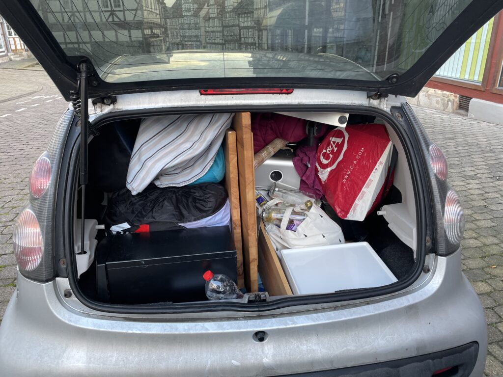 Small car filled with furniture and other belongings