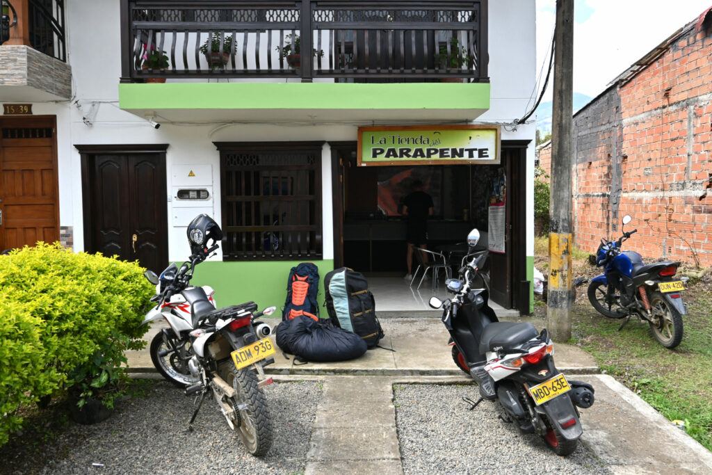 Paragliding shop with motorcycles in front of it and some paragliding backpacks