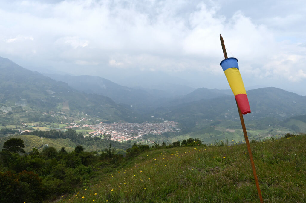 Windsock on a grass field with a town in the valley below