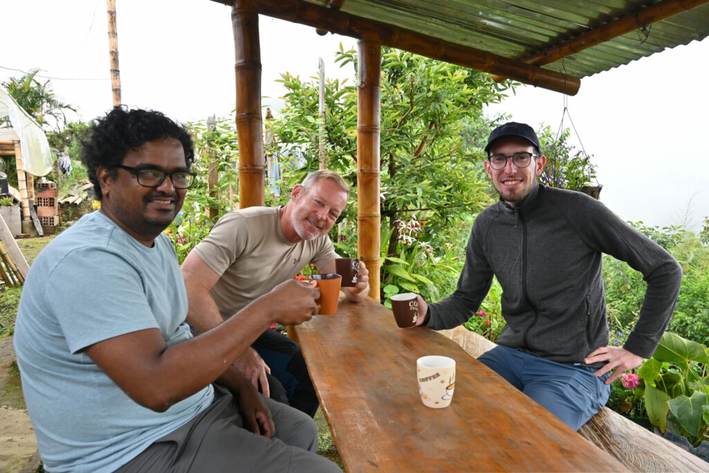 Three people siting at a desk with coffee cups