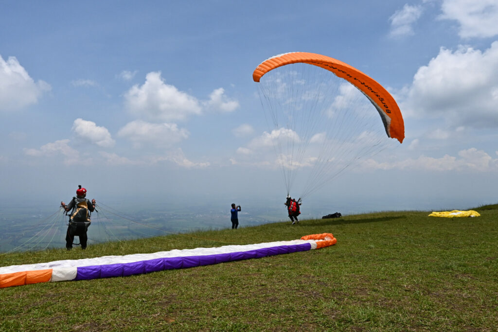 One paragliding taking off with another one waiting