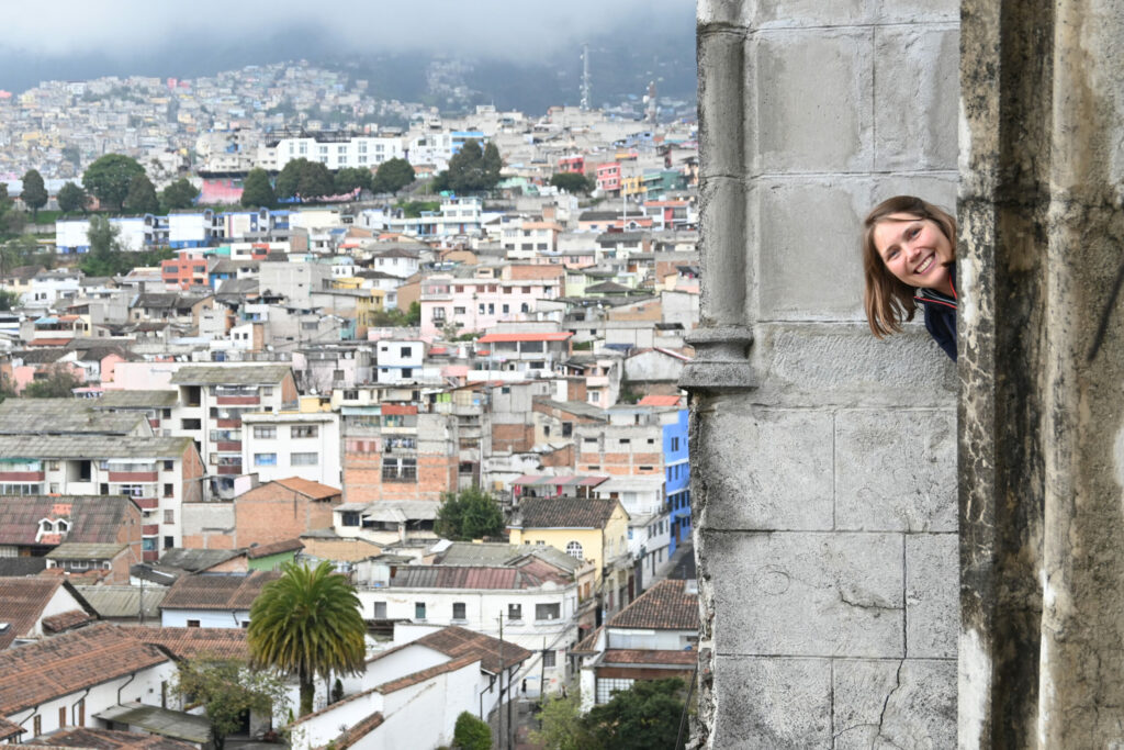 Katy looking out of a church window, Quito in the background