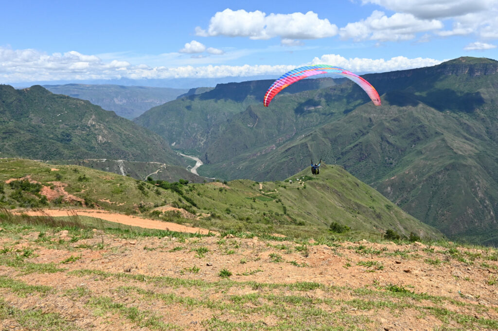 A paraglider, in the background mountains and a river